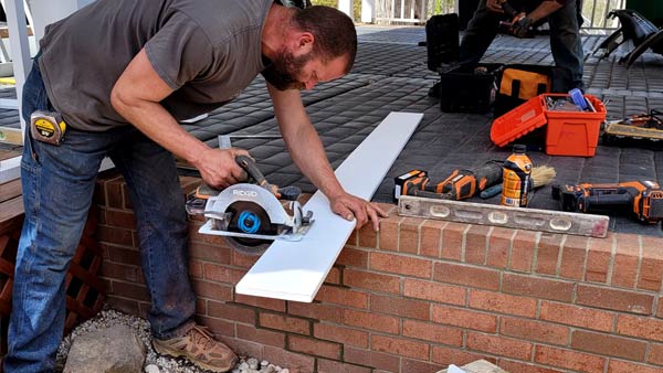 Brick or mortar cracking repaired cutting a  new pvc board with a ridged saw for one of the columns.