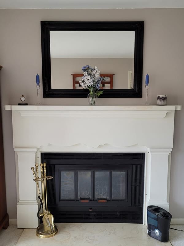 New black mirror over fireplace with flowers and candles